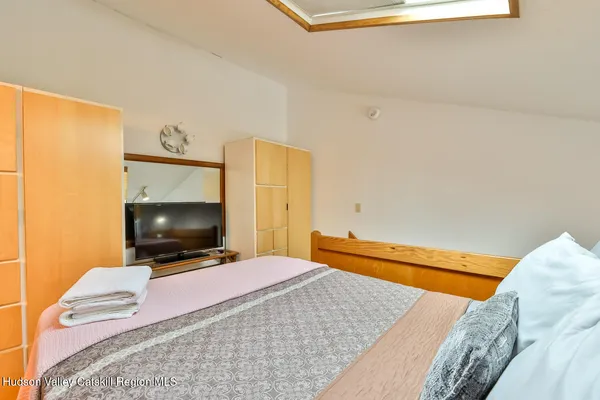 a bedroom with a bed and a flat screen tv