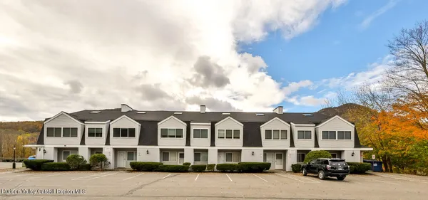 a front view of a house with cars parked