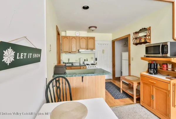 a kitchen with stainless steel appliances kitchen island granite countertop a stove a sink dishwasher and a dining table with wooden floor