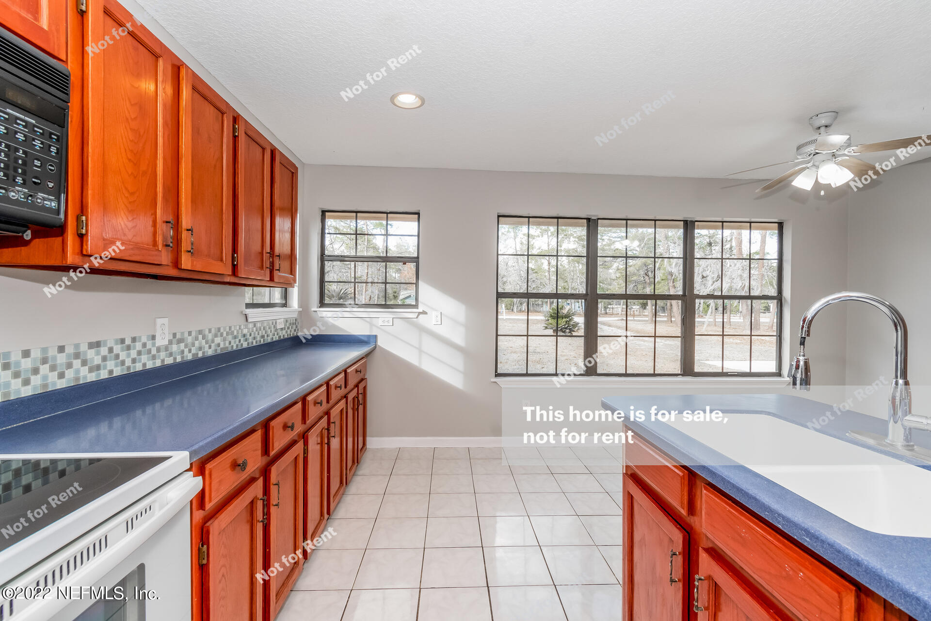 4205 Mustang Road Middleburg, FL 32068 - Photo 13 of 27 a kitchen with stainless steel appliances granite countertop a sink a stove cabinets and living room view