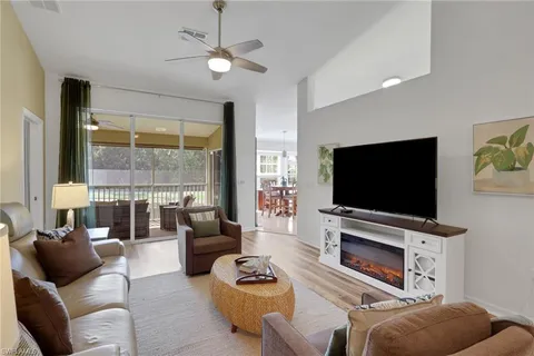 a living room with furniture a flat screen tv and a large window