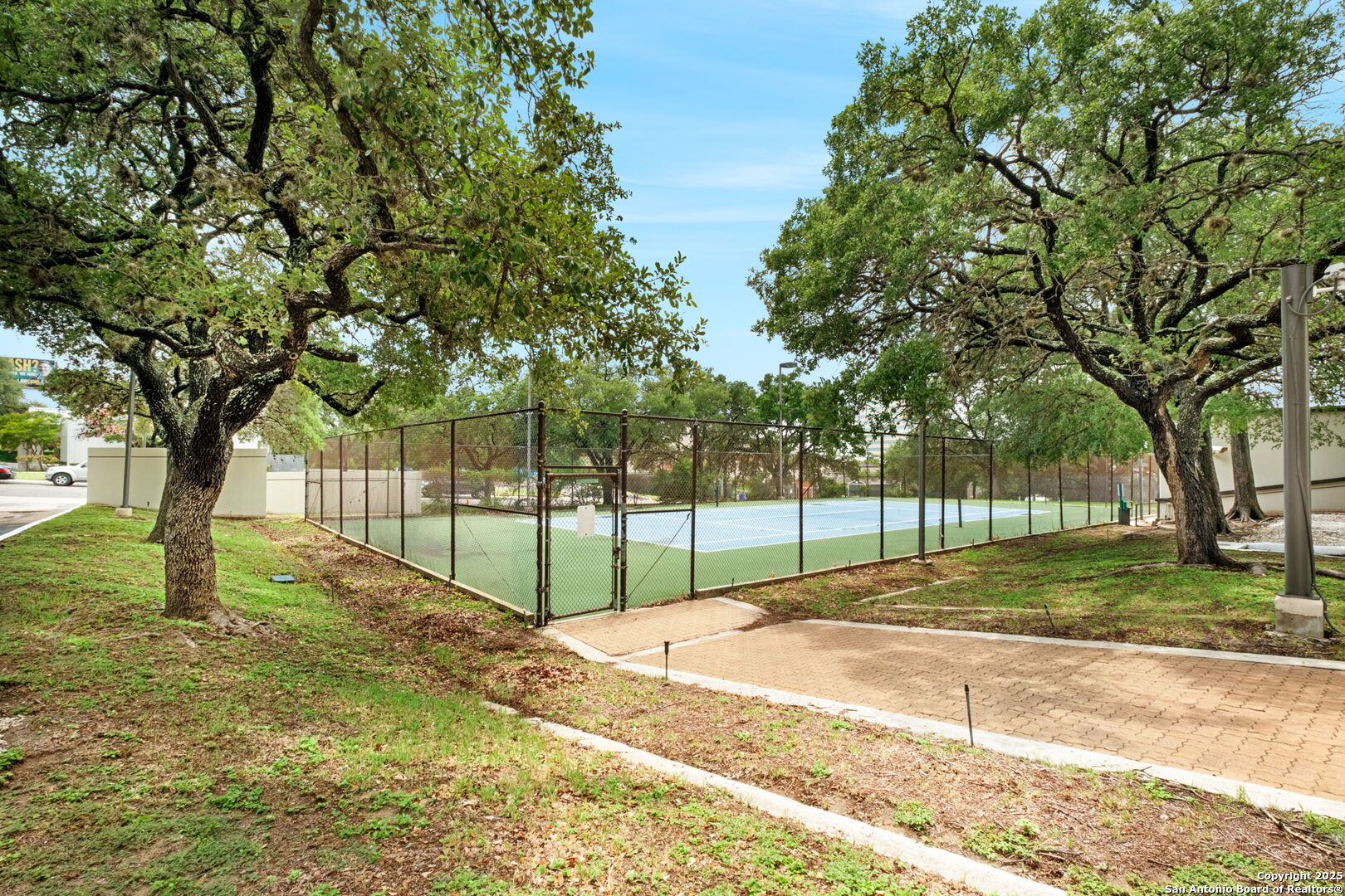 7701 Wurzbach Road, Unit 907 San Antonio, TX 78229 - Photo 25 of 25 a view of a yard with a house and trees in the background