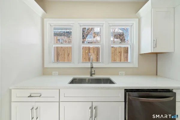 a kitchen with stainless steel appliances granite countertop a sink and a window