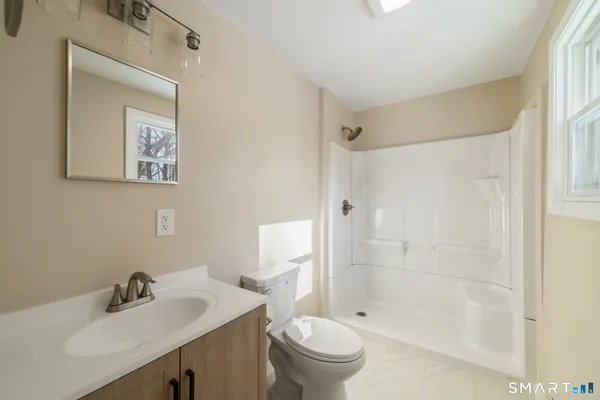 a bathroom with a sink toilet and shower