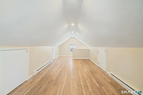 a view of empty room with wooden floor