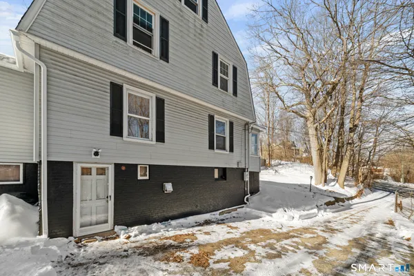 a front view of a house with a yard covered in snow