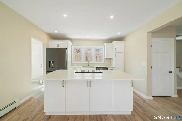 a kitchen with stainless steel appliances cabinets and wooden floor