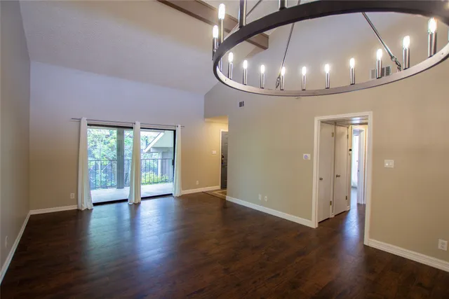 an empty room with wooden floor and staircase
