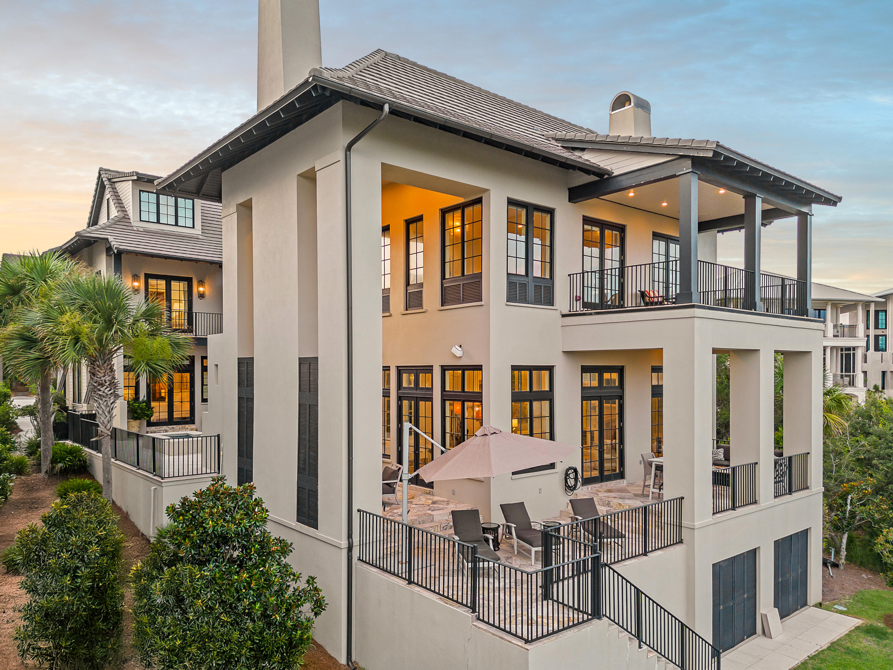 231 West Bermuda Drive Santa Rosa Beach, FL 32459 - Photo 3 of 47 a view of a white house with large windows and a table and chairs