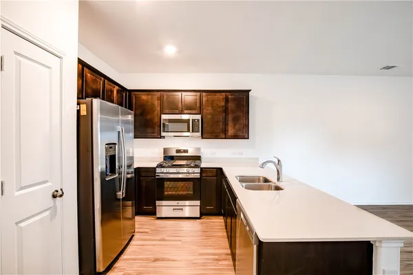 a kitchen with stainless steel appliances a stove microwave and refrigerator