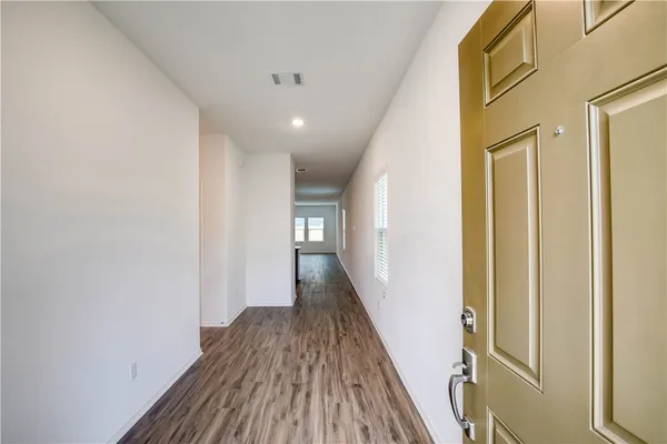 a view of a hallway with wooden floor and staircase