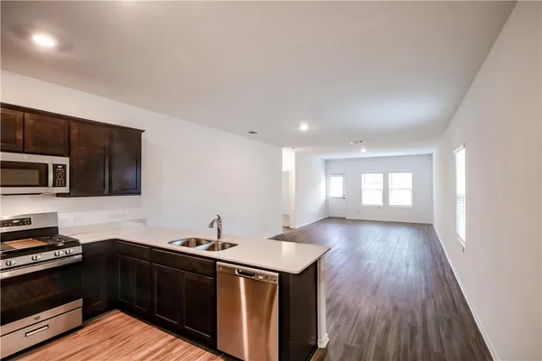 a kitchen with a sink and wooden floor