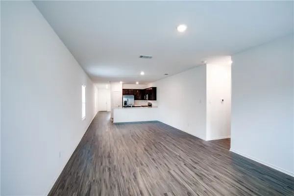 a view of a big room with wooden floor and windows