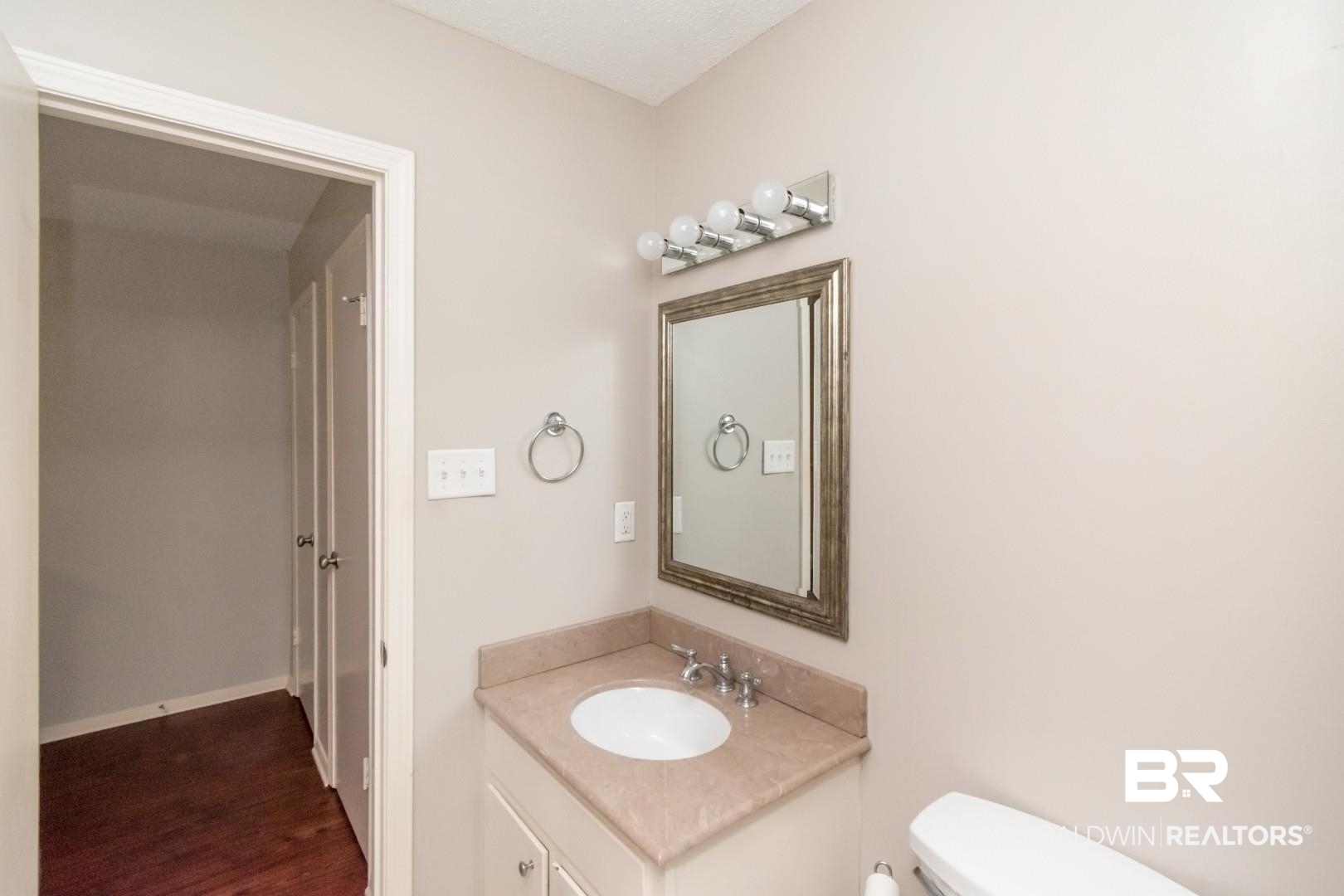118 Du Rhu Drive, Unit H Mobile, AL 36608 - Photo 16 of 19 Bathroom featuring a single vanity with an integrated sink, a light-toned countertop, and a framed mirror
