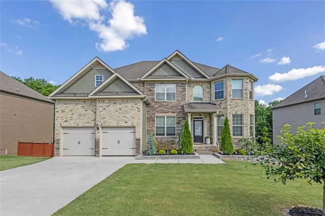 a front view of a house with a yard and garage