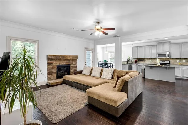 a kitchen with stainless steel appliances a sink dishwasher a refrigerator a stove top oven a wooden floor and cabinets