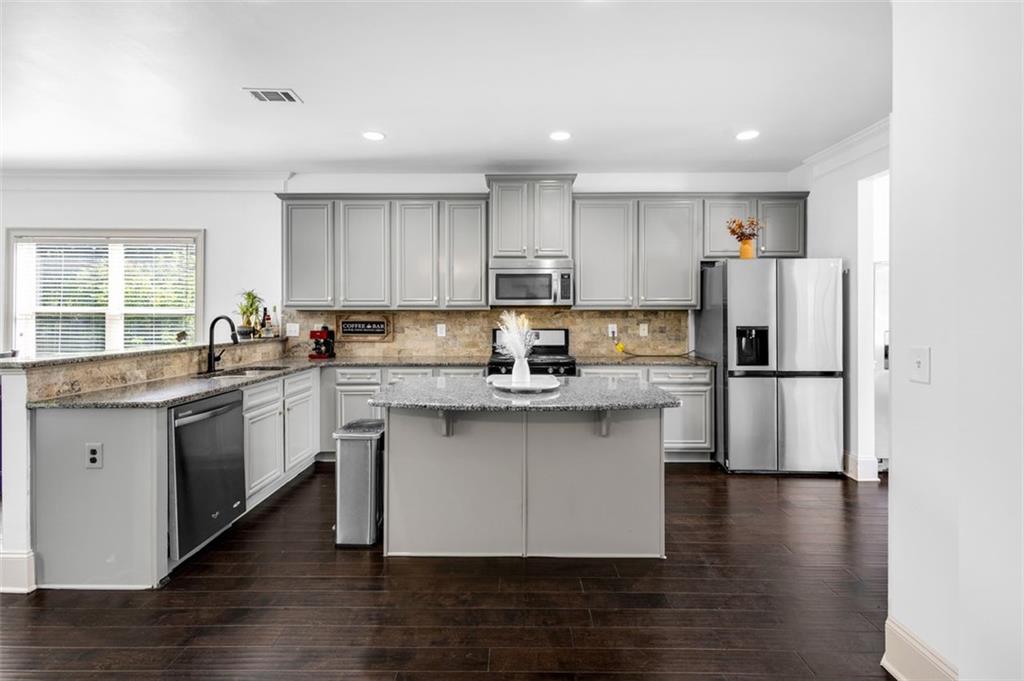 908 Rainsong Court Braselton, GA 30517 - Photo 22 of 79 a kitchen with stainless steel appliances granite countertop a refrigerator sink and stove