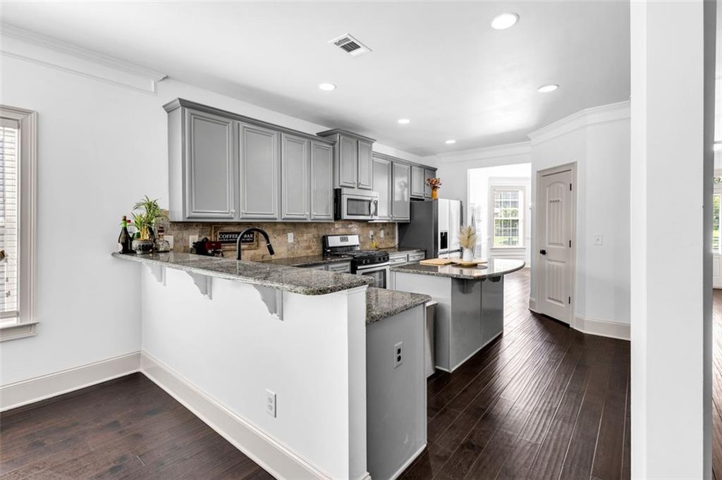 908 Rainsong Court Braselton, GA 30517 - Photo 23 of 79 a kitchen with stainless steel appliances granite countertop a sink a stove a refrigerator cabinets and a window