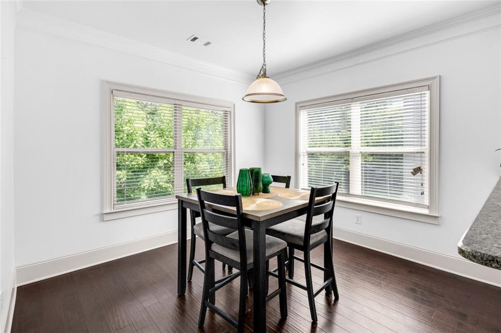 908 Rainsong Court Braselton, GA 30517 - Photo 24 of 79 a dining room with wooden floor a chandelier a glass table and chairs