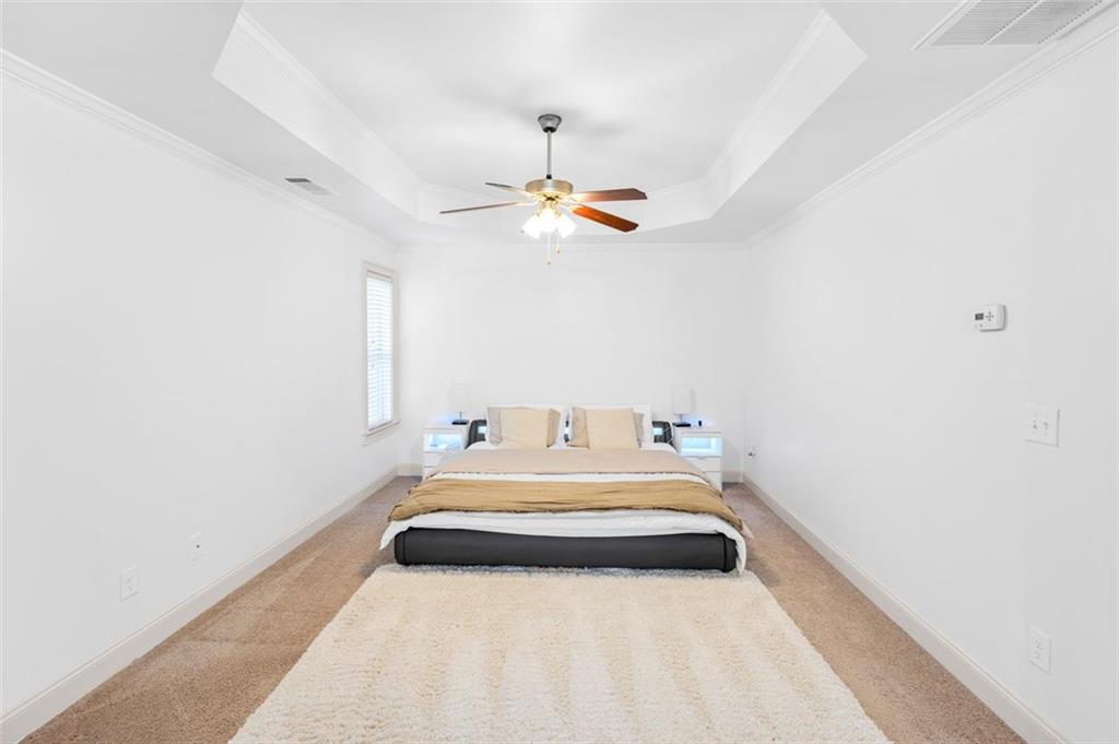 908 Rainsong Court Braselton, GA 30517 - Photo 54 of 79 a bedroom with a bed and a chandelier