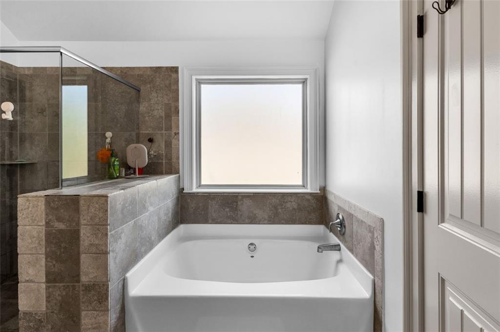 908 Rainsong Court Braselton, GA 30517 - Photo 59 of 79 a bathroom with a bathtub and shower