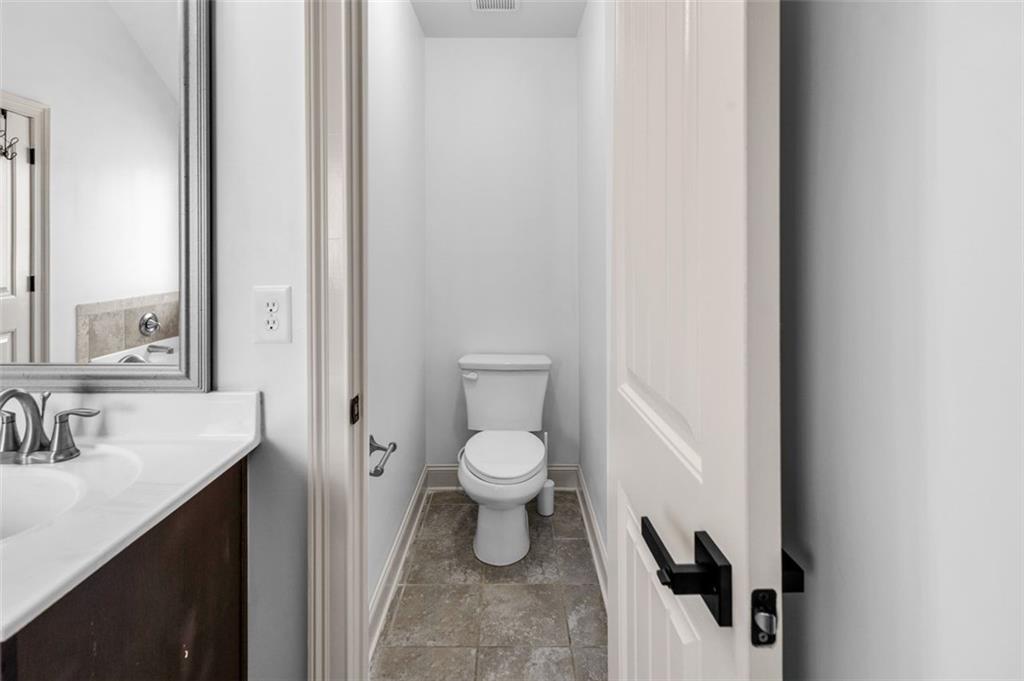 908 Rainsong Court Braselton, GA 30517 - Photo 60 of 79 a bathroom with a toilet a sink and mirror