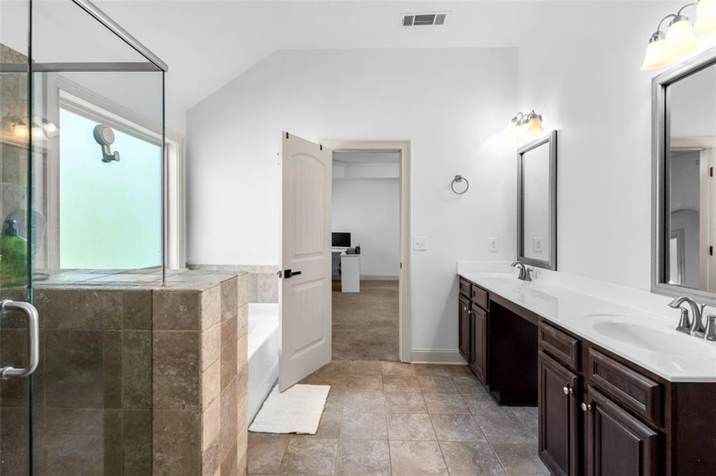 908 Rainsong Court Braselton, GA 30517 - Photo 62 of 79 a spacious bathroom with a double vanity sink a mirror and a shower
