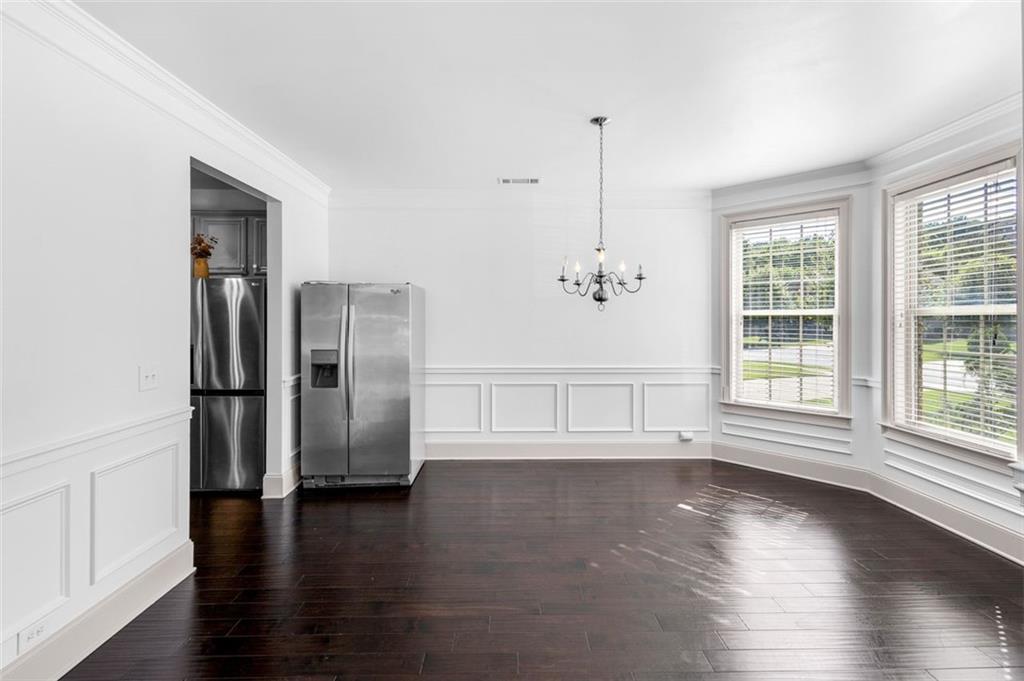908 Rainsong Court Braselton, GA 30517 - Photo 8 of 79 a view of an empty room with wooden floor and a window