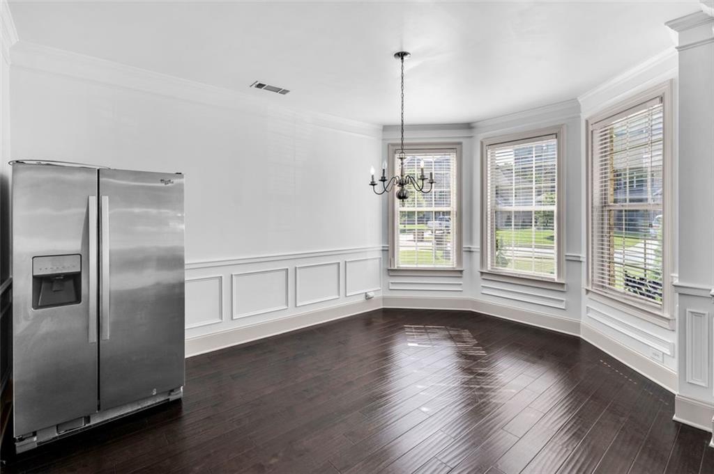 908 Rainsong Court Braselton, GA 30517 - Photo 9 of 79 a view of an empty room with wooden floor and a window