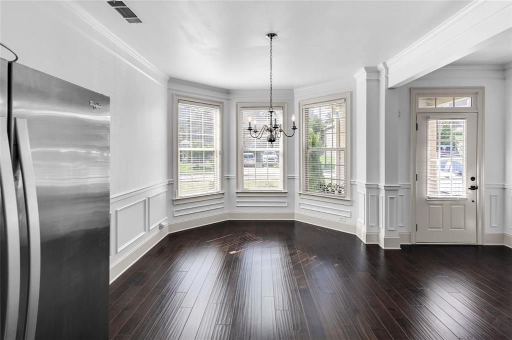 908 Rainsong Court Braselton, GA 30517 - Photo 10 of 79 a view of an empty room with wooden floor and a window