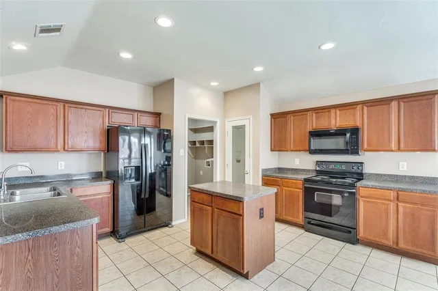 a kitchen with stainless steel appliances granite countertop a refrigerator stove and sink