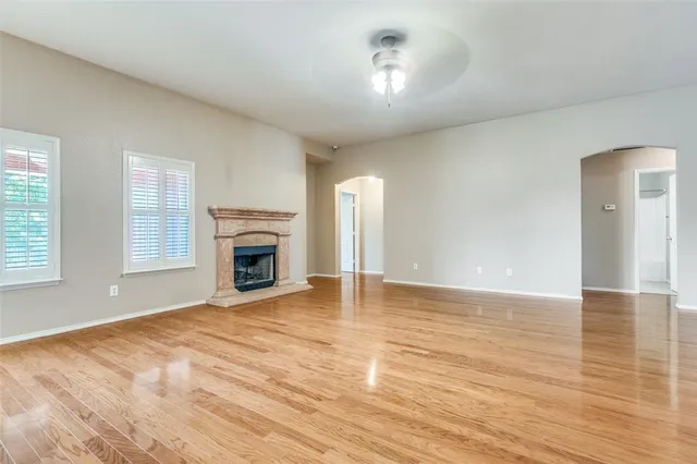 a view of empty room with wooden floor and fireplace
