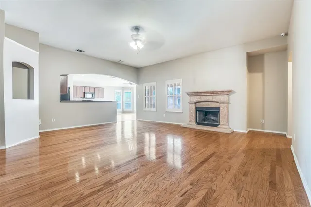 a view of empty room with wooden floor and fireplace