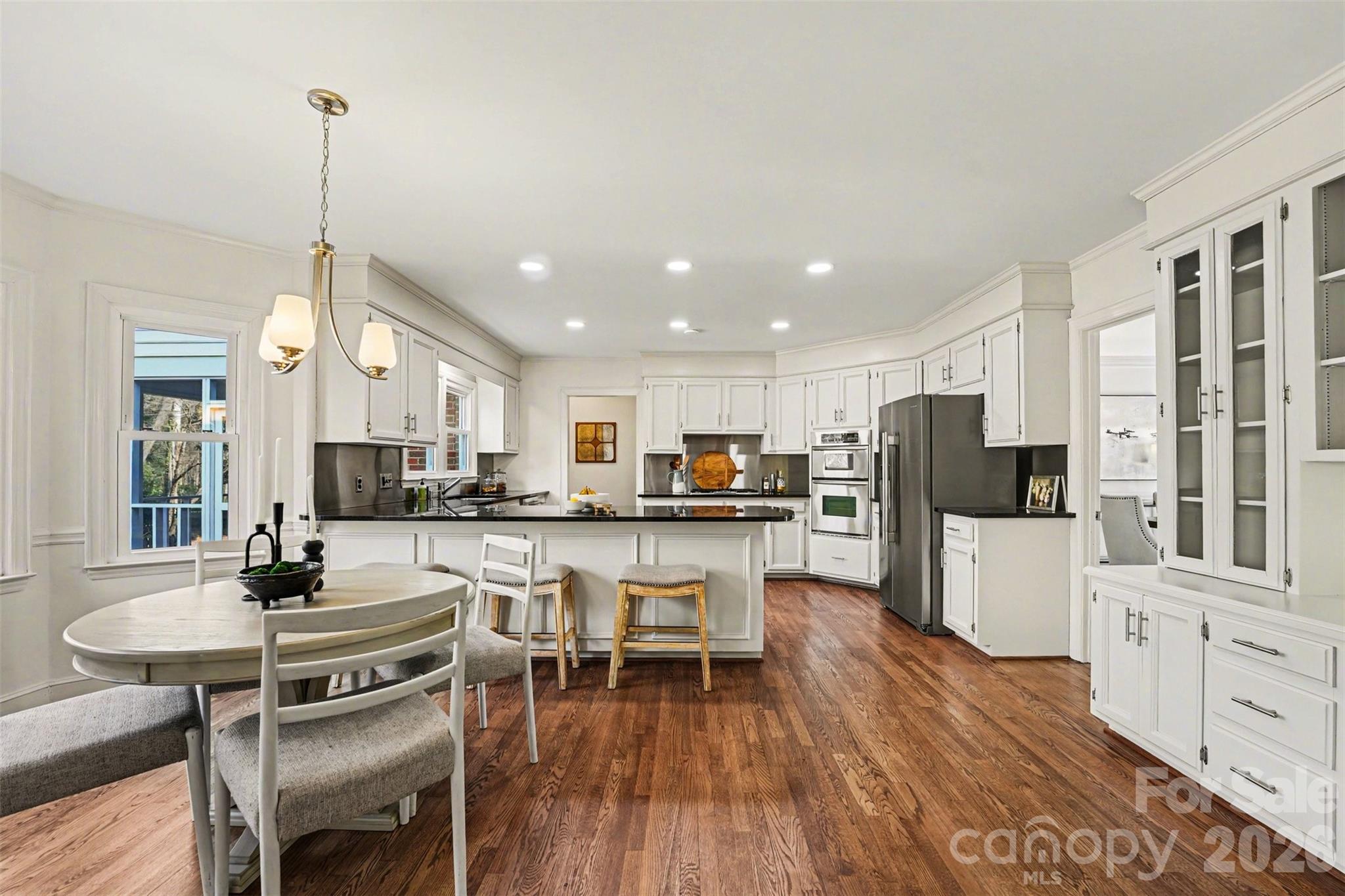 5606 Hillingdon Road Charlotte, NC 28226 - Photo 12 of 41 a kitchen with stainless steel appliances a dining table chairs stove and white cabinets