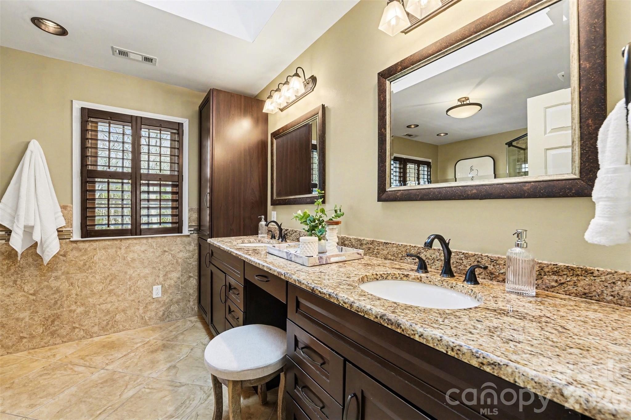 5606 Hillingdon Road Charlotte, NC 28226 - Photo 19 of 41 a bathroom with a granite countertop sink and a mirror