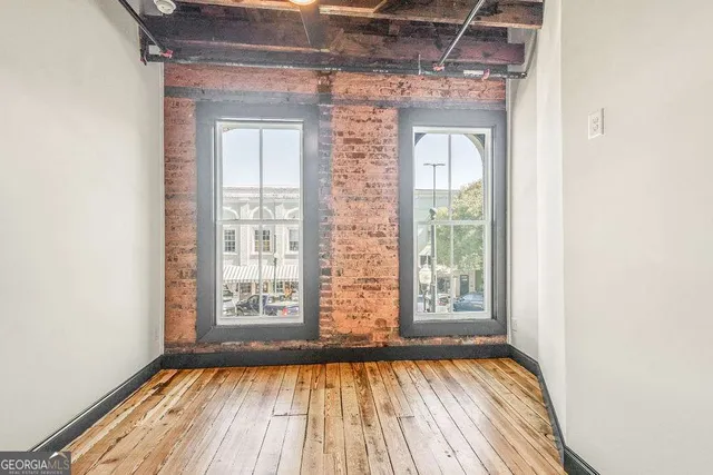 a view of a room with wooden floor and windows