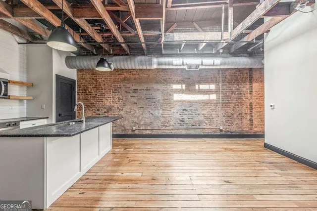 a view of a bathroom with stainless steel appliances granite countertop a sink and wooden floors
