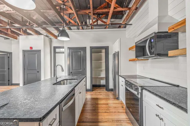 a kitchen with stainless steel appliances granite countertop a sink a stove and cabinets