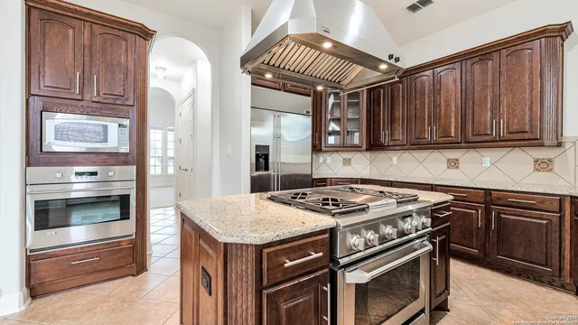 a kitchen with granite countertop a stove cabinets and stainless steel appliances