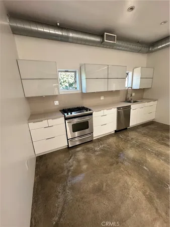 a kitchen with a stove and white cabinets