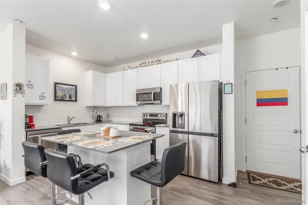a kitchen with granite countertop a refrigerator and a sink