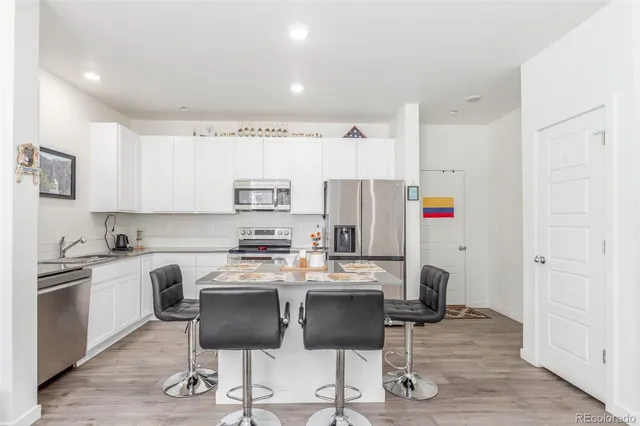 a kitchen with stainless steel appliances a refrigerator and a stove top oven
