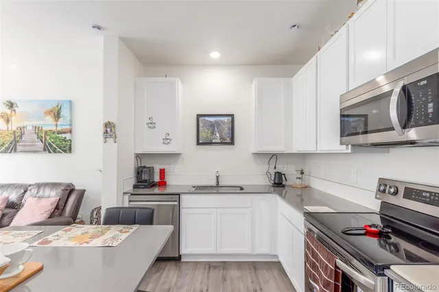 a kitchen with stainless steel appliances a stove a sink and a refrigerator