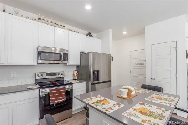 a kitchen with stainless steel appliances granite countertop a refrigerator sink and stove top oven