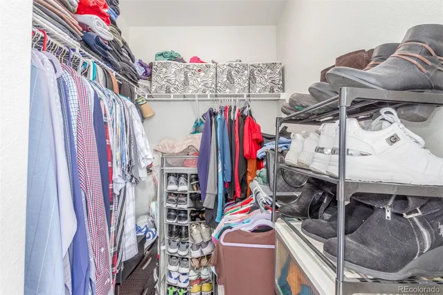 a view of walk in closet with clothes and shoes