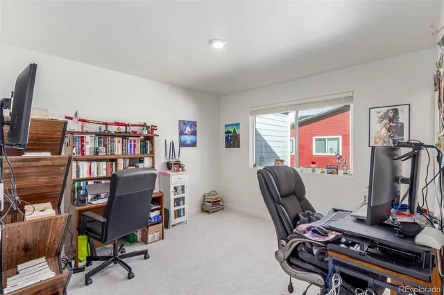 a view of a workspace with furniture and a window