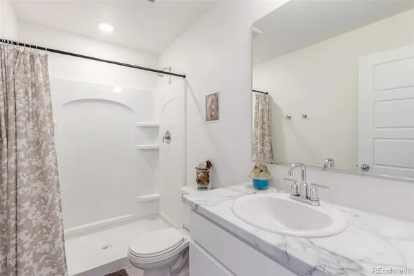 a bathroom with a sink a toilet and a large mirror