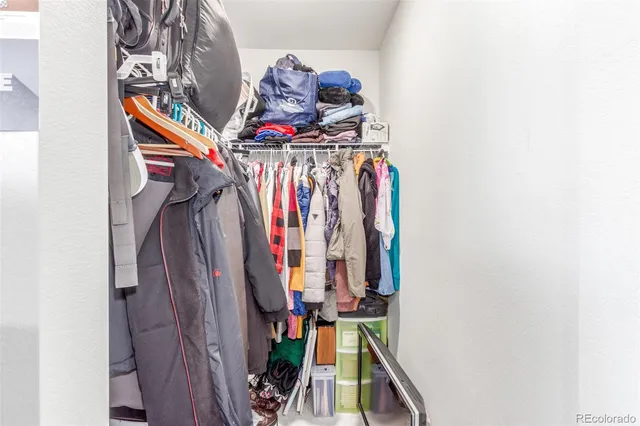 a view of walk in closet with clothes