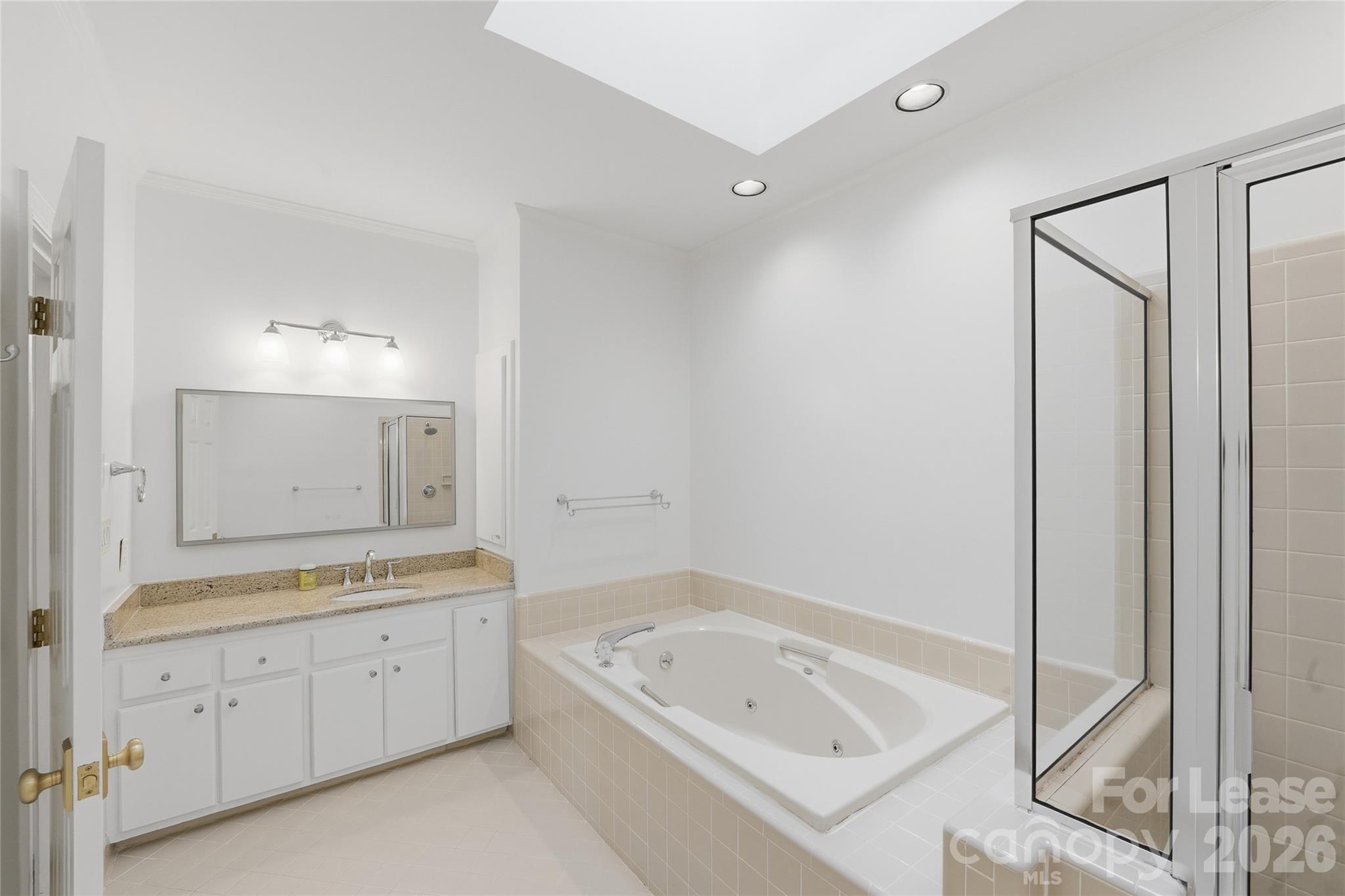 5906 Sharon Hills Road Charlotte, NC 28210 - Photo 21 of 30 a bathroom with a tub a sink and a mirror