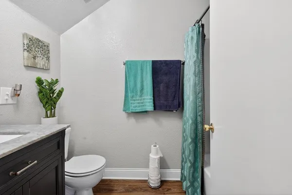 a bathroom with a granite countertop toilet sink and mirror